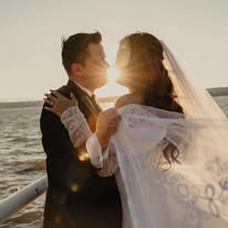 Pareja de novios al atardecer junto al agua